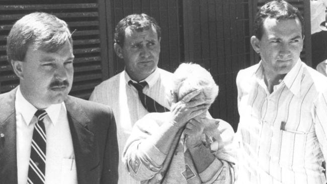 Valmae Beck is led by detectives to Wyong Court before her extradition to Queensland to face murder charges in December 1987.