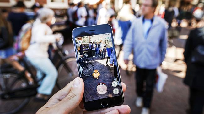 Gamers play with the Pokemon Go application on their mobile phone, at the Grote Markt in Haarlem, on July 13, 2016. Picture: Remko de Waal.