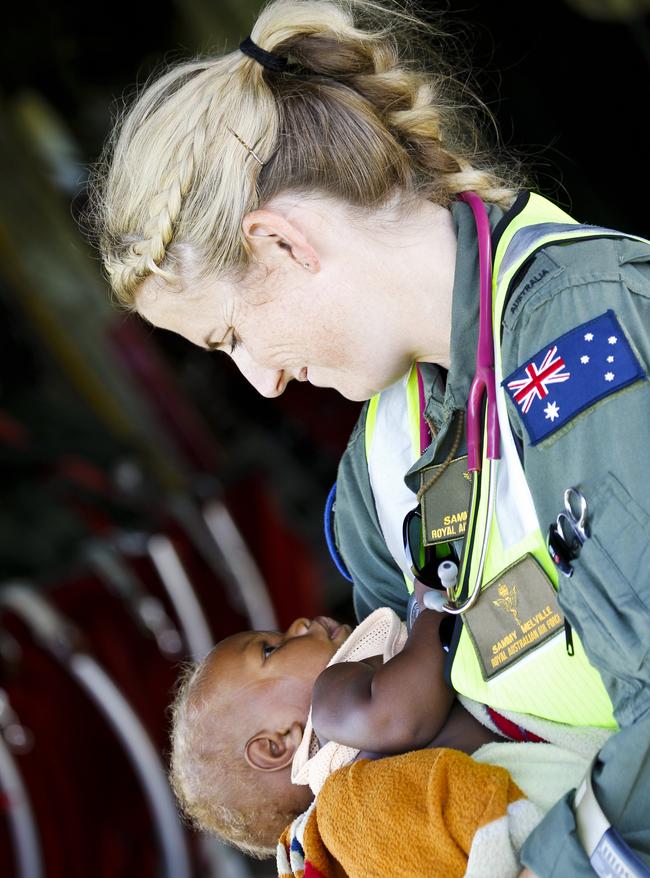 ADF Sergeant Sammy Melville cradles a baby evacuated from the Island of Tanna in Vanuatu during tropical Cyclone Pam in 2015. Picture: Supplied