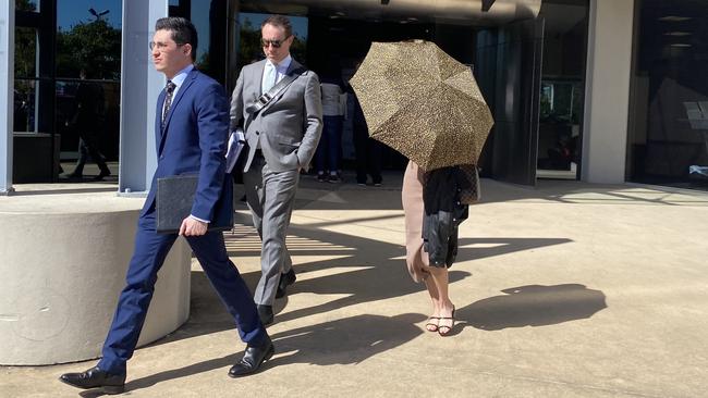 Jacqueline Bourne shields her face with an umbrella as she leaves court. Picture: Jacob Miley.