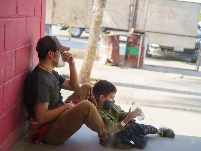 Jesus, 25, and his son Anthony, 5, from Honduras wait outside Gimnasio Kiki Romero, which has been converted into a makeshift migrant shelter, in Ciudad Juarez. Picture: AFP