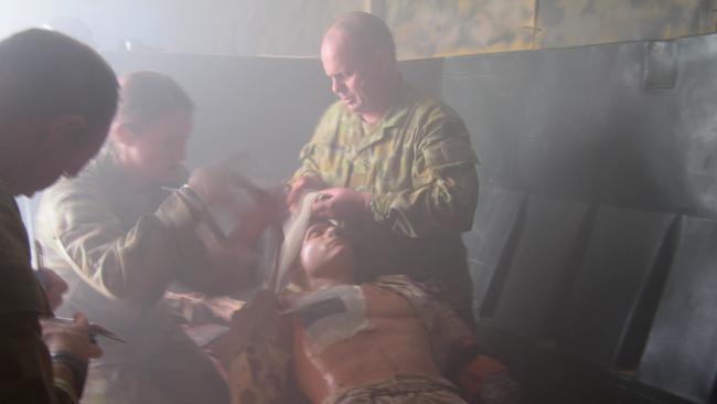 Australian troops apply first aid to a mannequin in a final combat first aid exercise at at the Australian support base in the United Arab Emirates. Picture: AAP Image/Max Blenkin