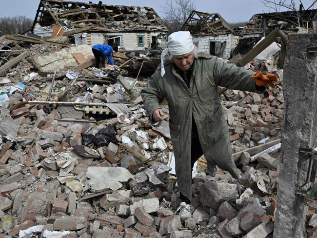 TOPSHOT - Svitlana Zavaly, 67, walks over the rubble of her house destroyed by a Russian bomb in the village Velyka Pysarivka, which lies just five kilometres from the Russian border, in Sumy region on March 24, 2024, amid the Russian invasion of Ukraine. (Photo by Genya SAVILOV / AFP)