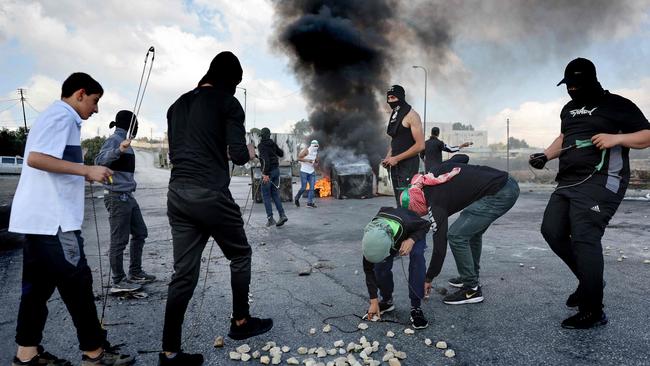 Palestinians use slingshots to throw stones towards Israeli soldiers during a demonstration in Ramallah, in the West Bank. Picture: AFP