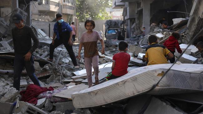 Children sit on a mattress as Palestinians check the site of an overnight Israeli strike in Jabalia in the central Gaza Strip. Picture: Bashar Taleb / AFP