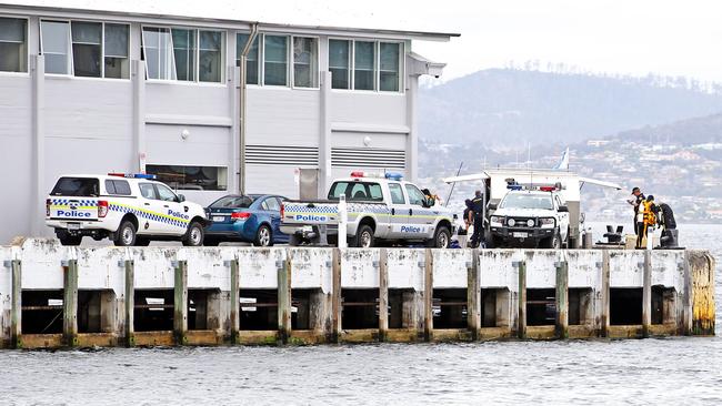 Tasmanian Police divers at the end of Elizabeth Street Pier where the body of a man was recovered. Picture: ZAK SIMMONDS