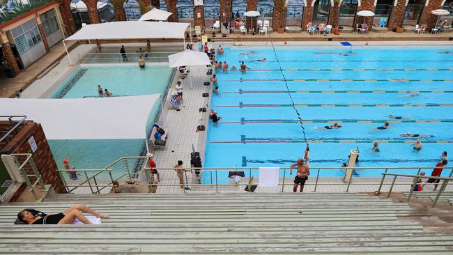 A swimmer relaxes in the grandstand of the pool. Picture: Toby Zerna