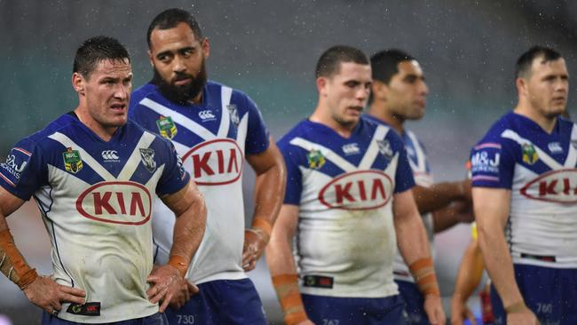 Dejected Bulldogs players stand together.