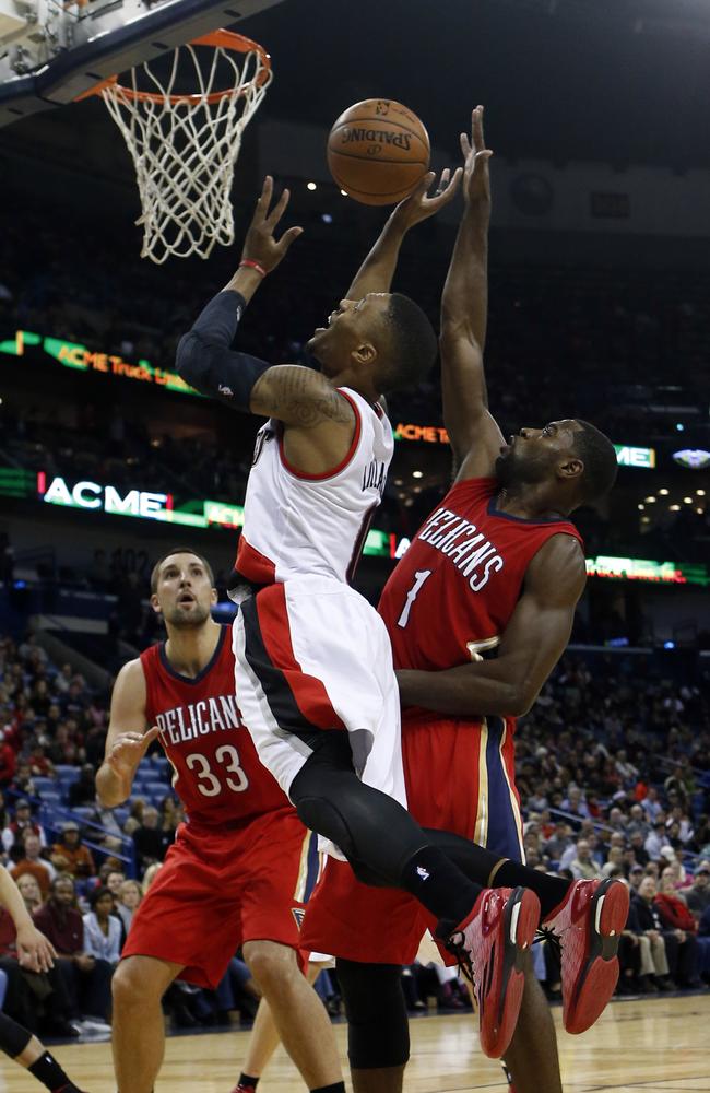 Portland Trail Blazers guard Damian Lillard, centre, drives to the basket around New Orleans Pelicans forward Tyreke Evans.