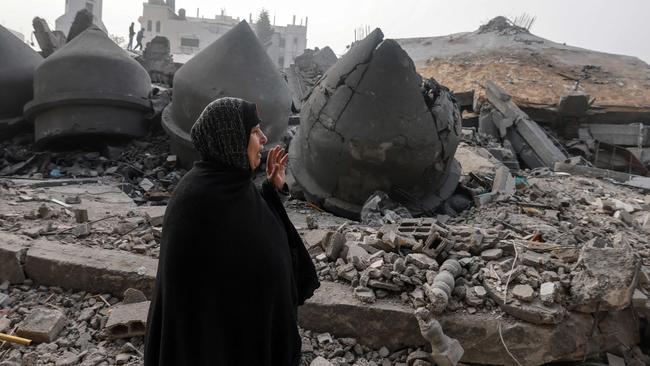 A woman walks near the Al-Faruq mosque, levelled by Israeli bombardment in Rafah in the southern Gaza Strip on February 25, 2024, amid continuing battles between Israel and the Palestinian militant group Hamas. (Photo by MOHAMMED ABED / AFP)