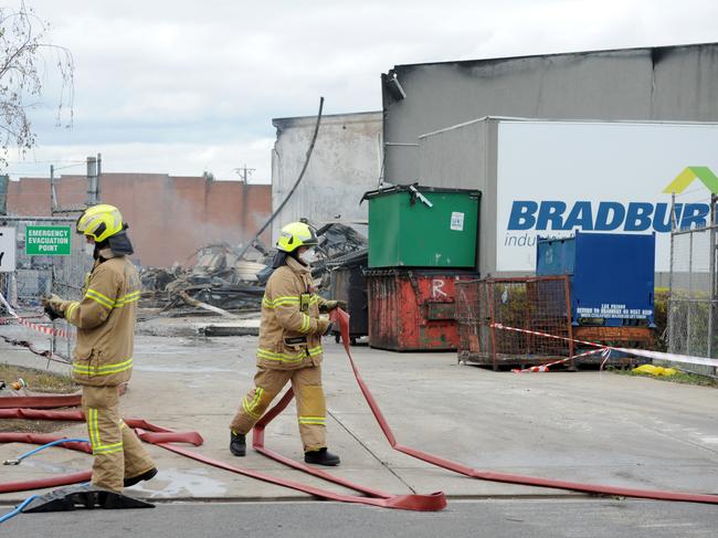 Fire crews mop up at the scene after a factory fire at Thornycroft Street Campbellfield. Picture: Andrew Henshaw