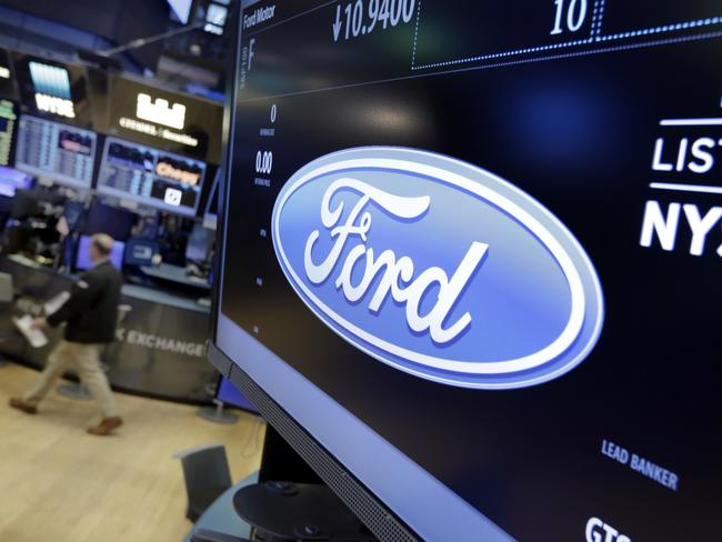 FILE - In this May 16, 2017 file photo, the logo for the Ford Motor Company appears above a post on the floor of the New York Stock Exchange.  Ford Motor Co. said Wednesday, May 17,  it plans to cut 10 percent of its salaried jobs in North America and Asia Pacific this year in an effort to boost profits.(AP Photo/Richard Drew)