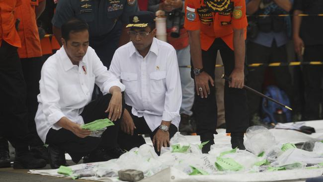 Indonesian President Joko Widodo, left, Transportation Minister Budi Karya Sumadi, center, and Chief of National Search and Rescue Agency Muhammad Syaugi, right, inspect debris and passengers' personal belongings. Picture: AP