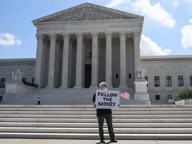 A man holds a sign in front of the US Supreme Court in Washington, DC. The court ruled that US President Donald Trump must hand over financial records to prosecutors. Picture: AFP