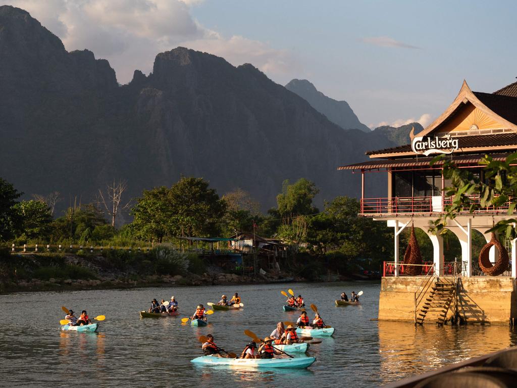 “Tubing” and paddling are popular tourist activities along the Nam Song river in Vang Vieng, Laos. Picture: AFP