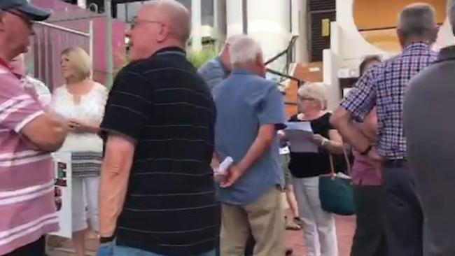 Still grab of residents gathering outside the Onkaparinga Council chambers. Picture: Celeste Villani