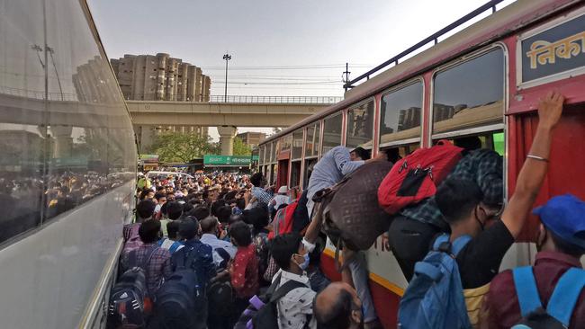 People clamour aboard a bus in New Delhi in a rush to reach their homes after a week-long lockdown was ordered on Monday night. Picture: AFP