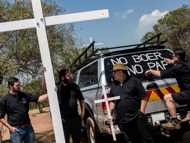 Members of the South African civic organisation, Afriforum and others in solidarity with the #Blackmonday movement carry crosses used for a demonstration against farm murders, at the Voortrekker Monument in Pretoria on October 30, 2017.  Thousands of white farmers blocked roads in South Africa on Monday to protest against what they say is an explosion of violence against their communities in rural areas. Large demonstrations under the "Black Monday" banner were held in Cape Town, Johannesburg and the capital Pretoria. Marchers dressed in black to commemorate the victims of hundreds of deadly "farm attacks" in recent years. / AFP PHOTO / GULSHAN KHAN