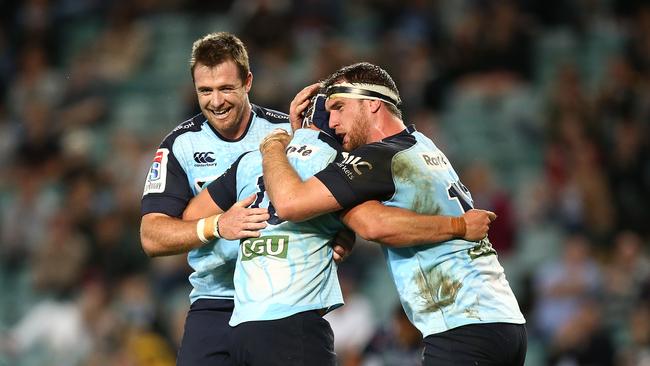 Damien Fitzpatrick of the Waratahs celebrates scoring a try with teammates.