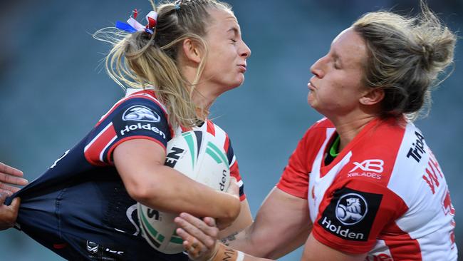 Brydie Parker of the Roosters (left) is tackled by Holli Wheeler of the Dragons.