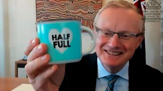 Philip Lowe holds up glass “half full” mug while giving testimony by video link at semi-annual parliamentary grilling in 2021.