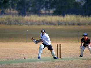 Adam Cummins changes his grip to go for a right-handed sweep at Wheatvale on Saturday. Hugh Inmon is keeper on a field where the drought is very evident. Picture: Gerarda Walsh