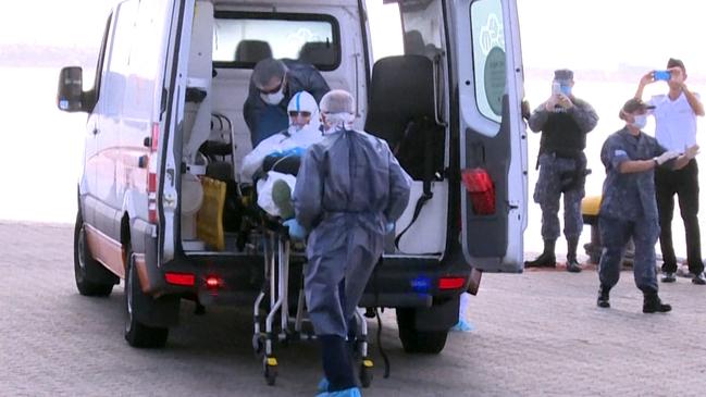 A 75-year-old Australian passenger from the MV Greg Mortimer is loaded onto an ambulance at Montevideo, Uruguay. Picture: AFP