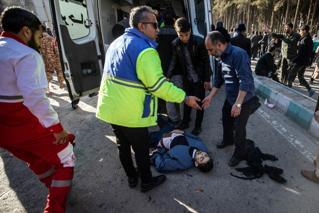 Iranian emergency services arrive at the site in Kerman city where two explosions killed at least 103 people, according to state media