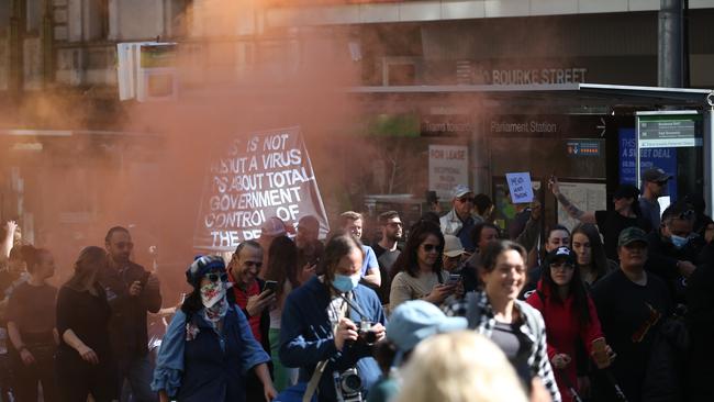 Protesters march through the streets of Melbourne, setting off flares. Picture: Matrix