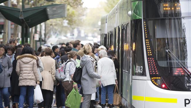 Crowds of people getting on and off a tram in Bourke Street. Picture: Sarah Matray