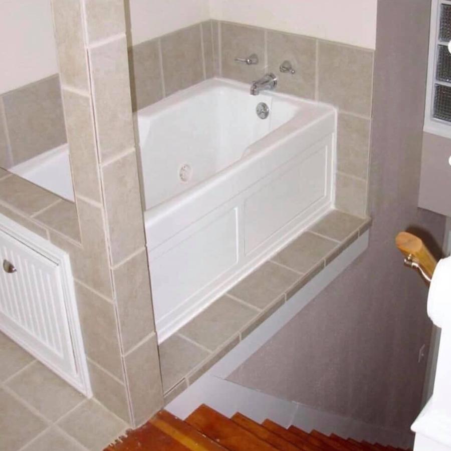 The other bathroom had a tub situated right next to a flight of stairs.