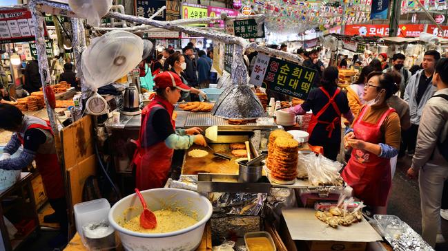 Vendors make mung bean pancakes at Gwangjang Market, Seoul, South Korea.