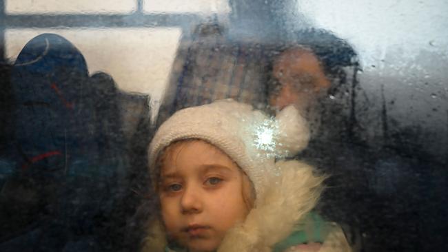 A girl fleeing the conflict in Ukraine looks on from inside of a bus heading to the Moldovan capital Chisinau, after crossing the Moldova-Ukraine border checkpoint. Picture: AFP