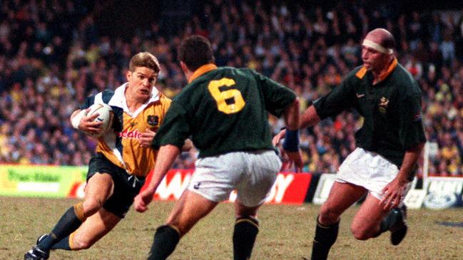 Tim Horan takes on Springbok player Johan Erasmus.