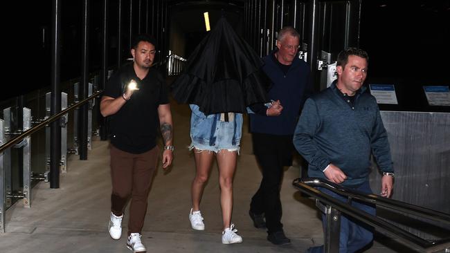 Taylor Swift (covered with umbrella) holds her dad’s hand (second from right) at Neutral Bay wharf on Tuesday morning. Picture: Matrix