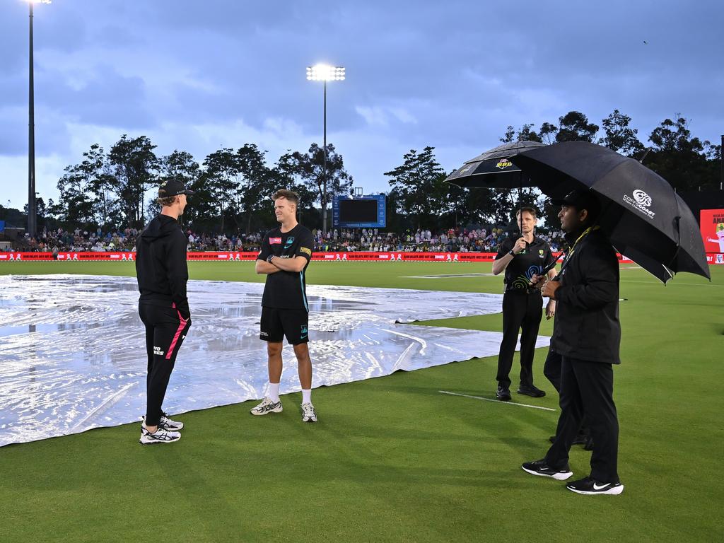 Sydney Sixers’ Jordan Silk and Brisbane Heat’s Matt Kuhnemann speak as the umpires inspect the field. Picture: Getty Images