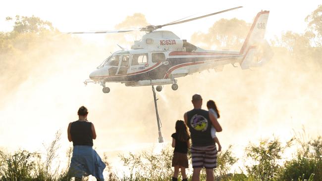 10Emergency service helicopters pick up water from a local golf course. Picture: Lyndon Mechielsen/The Australian