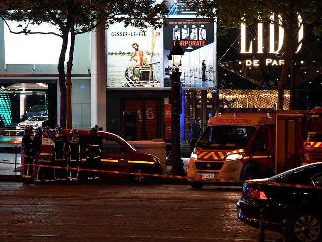 Firefighters and rescuers stand by the site of a shooting on the Champs Elysees in Paris.