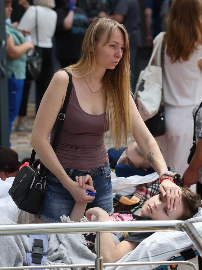 A woman touches a patient near Okhmatdyt Children’s Hospital that was damaged during Russian missile strikes. Picture: Reuters