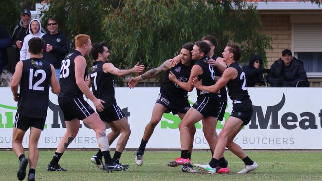 Gavin Shephard (middle) is surrounded by teammates after kicking a crucial fourth-quarter goal against Unley Mercedes in round six. Picture: Kym Stegmeyer