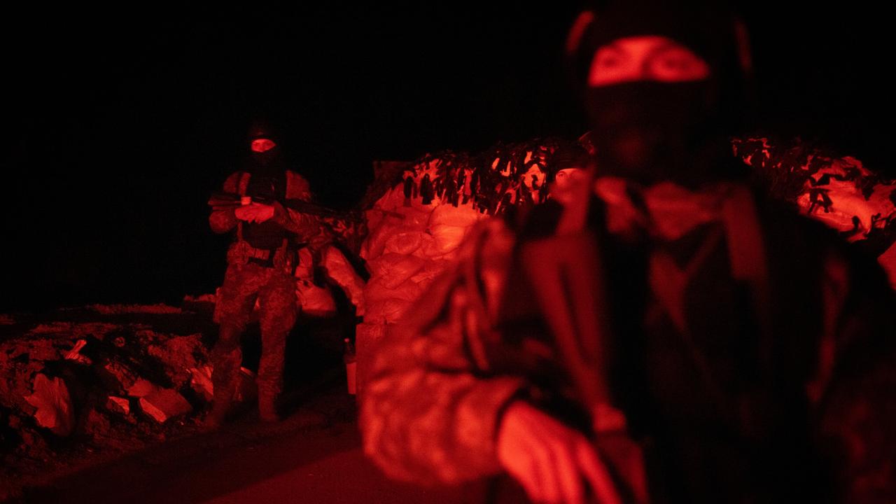 Members of the 127th Territorial Defense Force brigade search vehicles after curfew on a road on the outskirts of Kharkiv. Picture: Chris McGrath/Getty Images