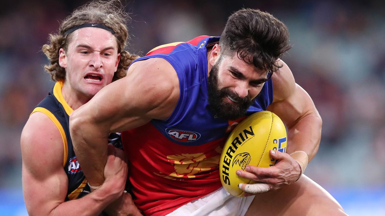 Sam Berry puts a tackle on Brisbane defender Marcus Adams last season.