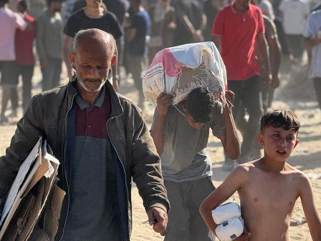 TOPSHOT - Displaced Palestinians receive food packages from a US-backed foundation pledging to distribute humanitarian aid in western Rafah in the southern Gaza Strip on May 27, 2025. (Photo by AFP)