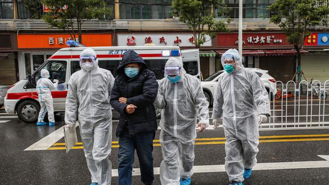 Medical staff walk a patient into a hospital in Wuhan. Picture: AFP/STR