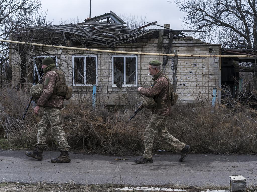 Ukrainian soldiers walk past a destroyed house. Picture: Brendan Hoffman/Getty Images