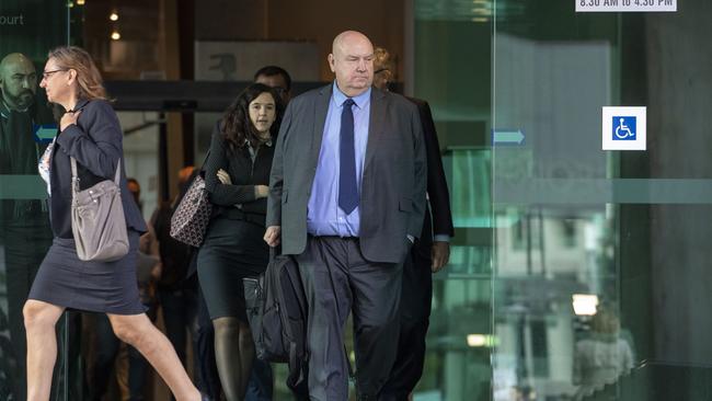 Warren Day (centre), of ASIC, leaves the royal commission in Brisbane after giving evidence. Pic: AAP