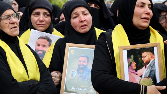 Mourners react during the funeral procession of a Hezbollah fighter and two of his relatives. Fight Ali Bazzi can be seen in the middle picture frame. Picture: AFP