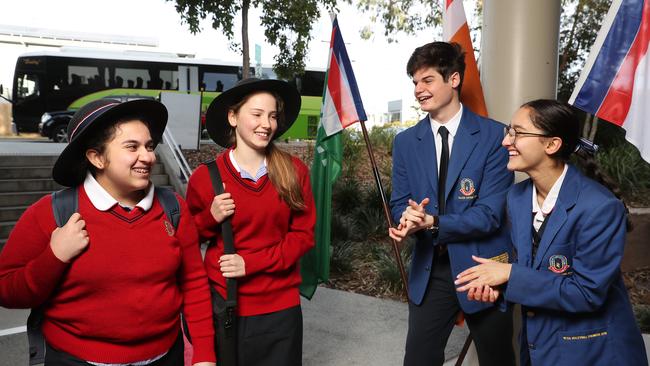 Cannon Hill Anglican College year 7’s Jemimah Rego and Victoria Seng are welcomed back to school by school captains Navneet Singh and Lachlan Parenti. Picture: Peter Wallis