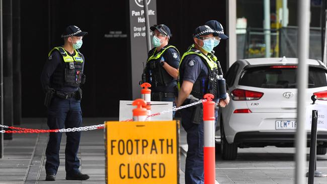 Police stand guard outside a Melbourne hotel being used to quarantine international travellers. Picture: AFP