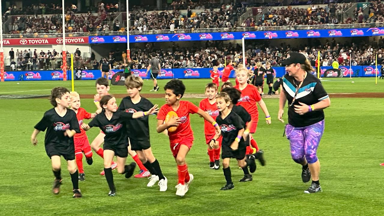 Cristelle Mulvogue, right, umpires juniors at the Gabba.